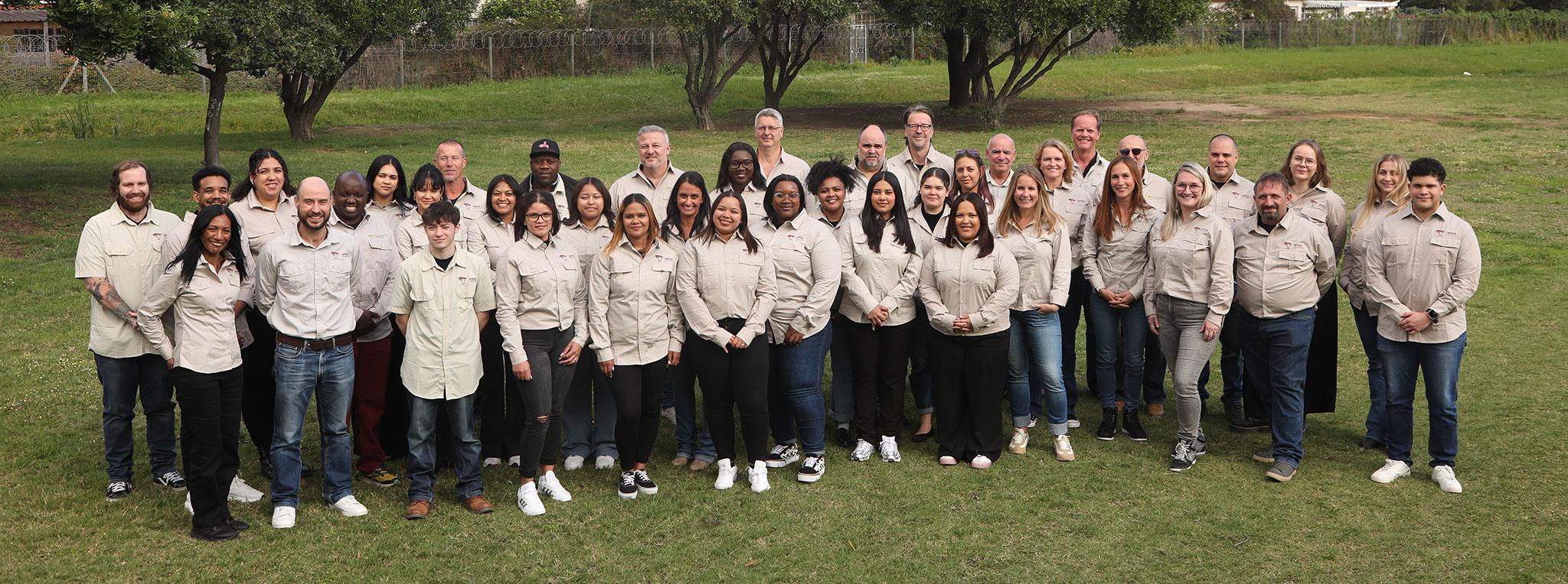 Team photo of South Affrica safari specialists in uniform outdoors.