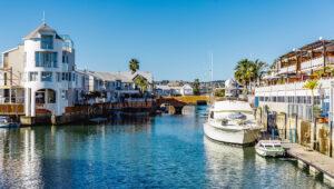 Waterfront marina canal with moored boats and waterside homes in Knysna, Garden Route, South Africa.