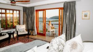 Woman on balcony overlooking the water in Knysna, South Africa.