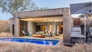 Private plunge pool and outdoor lounge area at Sabi Sabi Earth Lodge suite, surrounded by bush at dusk.
