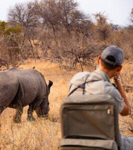 Ranger watching rhino on South African safari game drive through Isimangaliso Wetland Park.