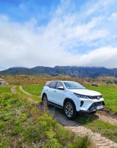 Self drive vehicle in Drakensberg Mountain landscape.