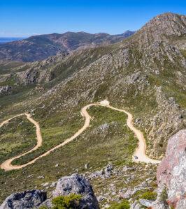 A windy dirt road through the mountains.