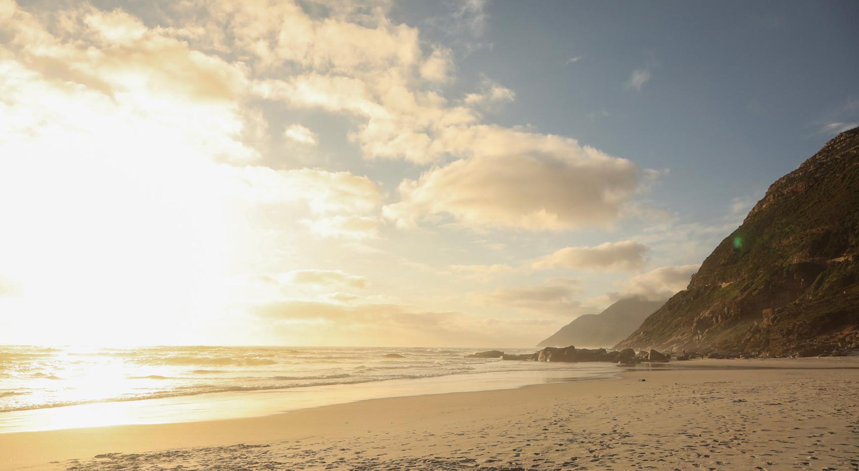 Sunset over a beach in Cape Town, South Africa, with mountains in the background. Best time to visit Cape Town. Sunset over a beach in Cape Town, South Africa, with mountains in the background. Best time to visit Cape Town.