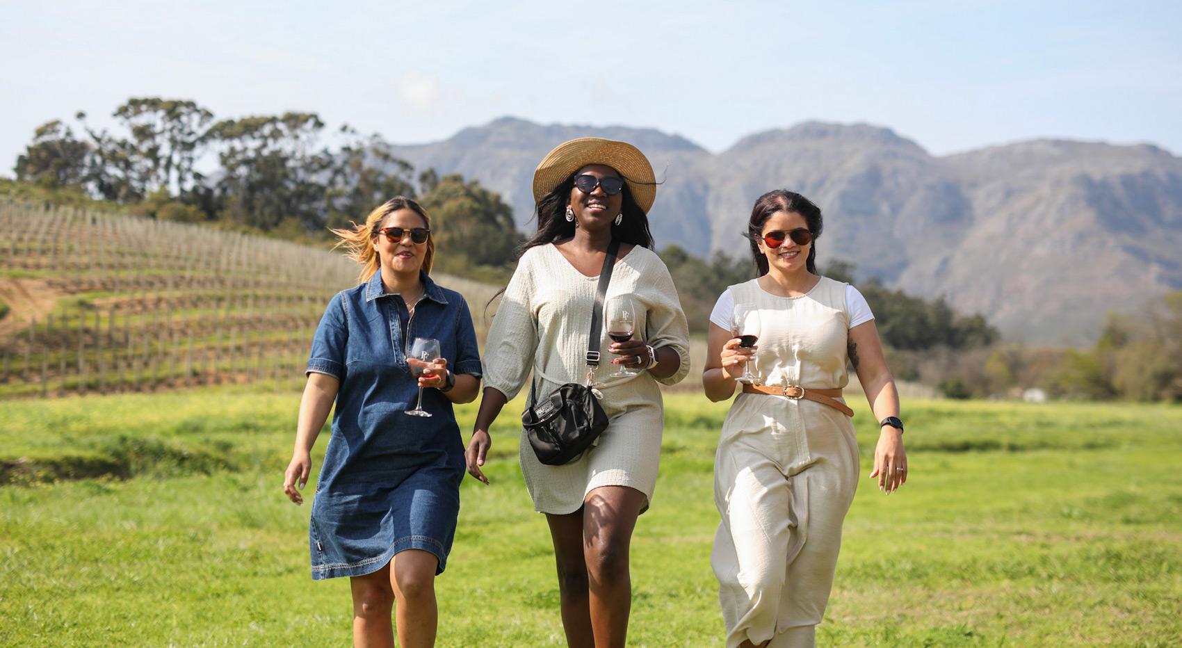 Women enjoying wine tasting in a vineyard, ideal for visiting Cape Town. Women enjoying wine tasting in a vineyard, ideal for visiting Cape Town.