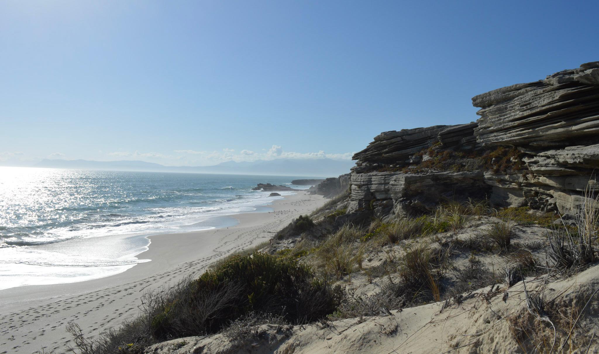 Rugged South African coastline with rocky cliffs and sandy beach