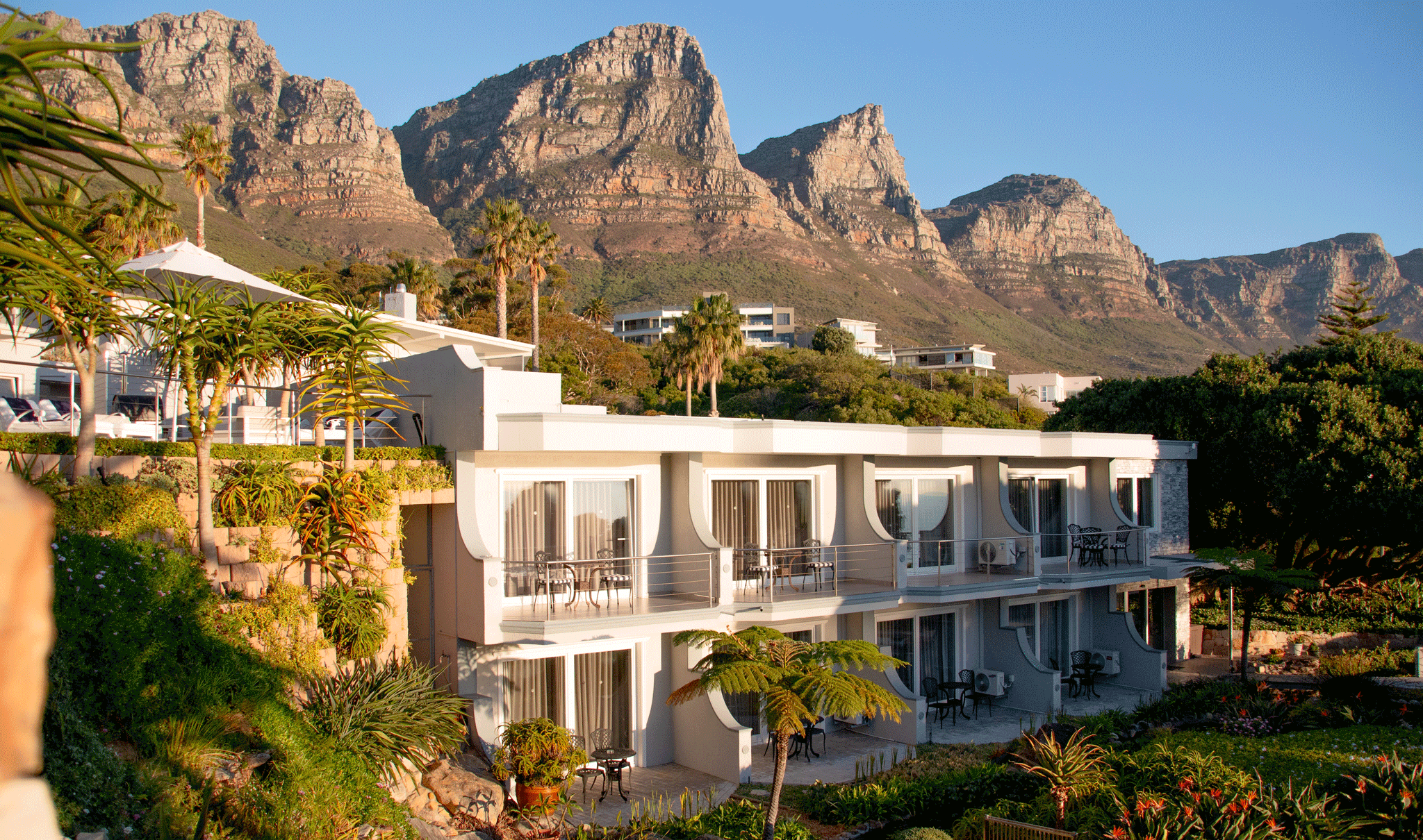 Modern hotel with balconies against the backdrop of the Twelve Apostles mountains, South Africa.
