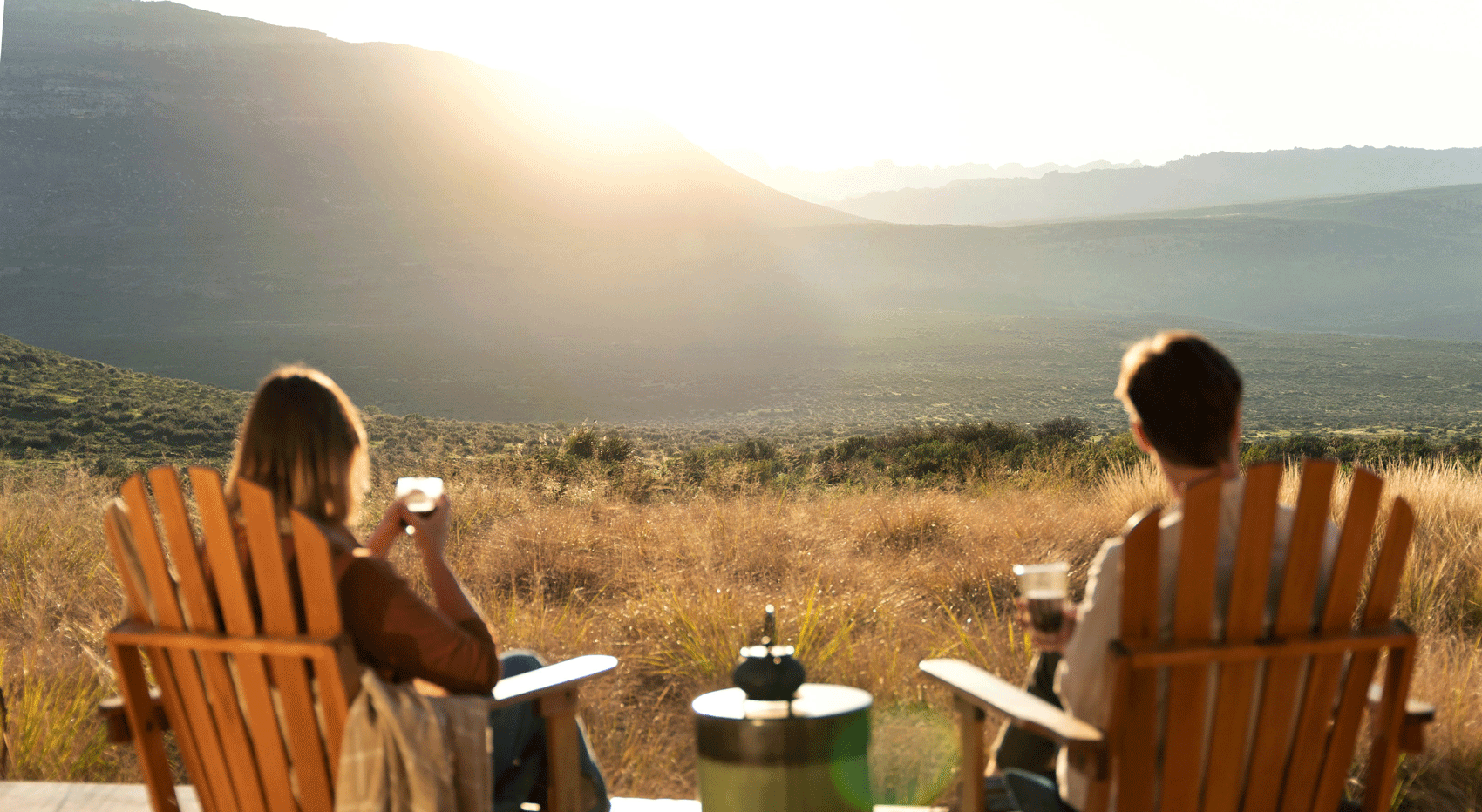Couple enjoying sunset view from deck in South Africa, offering self-drive tips. Couple enjoying sunset view from deck in South Africa, offering self-drive tips.