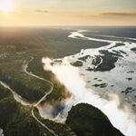 Victoria Falls seen from above, with water pouring over the cliffs into the gorge below.