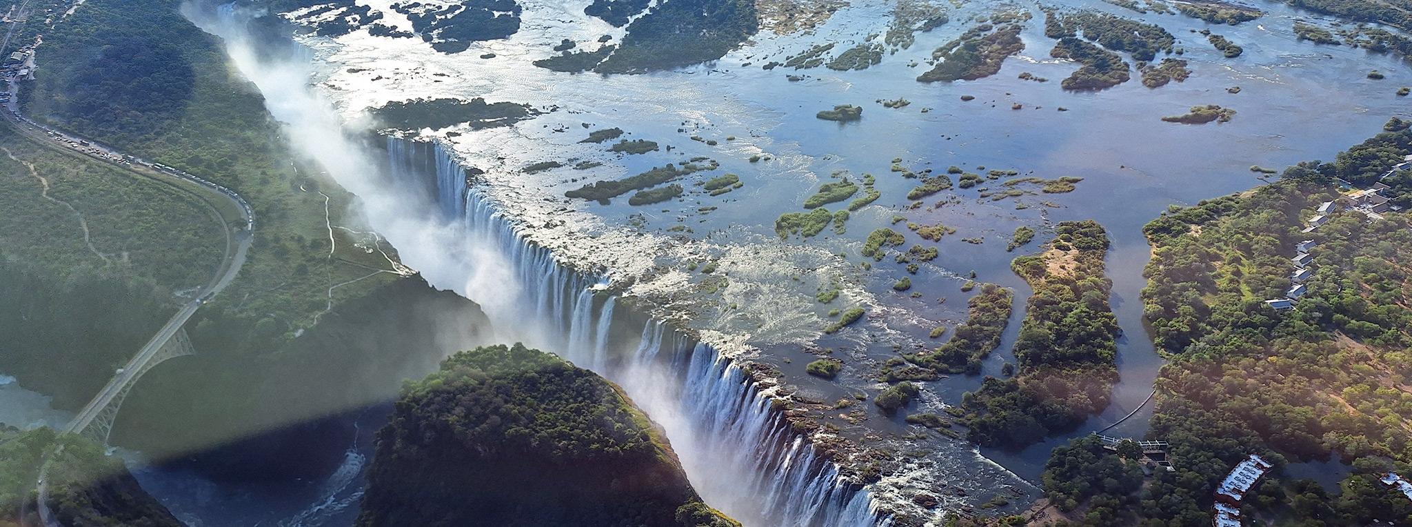 Victoria Falls seen from above, with water pouring over the cliffs into the gorge below.