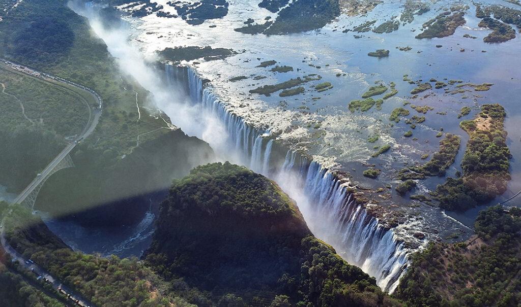 Victoria Falls seen from above, with water pouring over the cliffs into the gorge below.